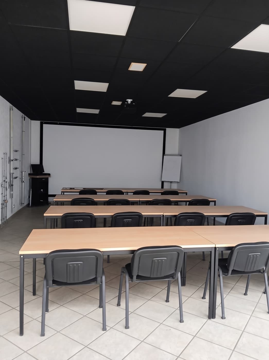 Schulungsraum in Kremmen mit Tischreihen, Leinwand und Flipchart